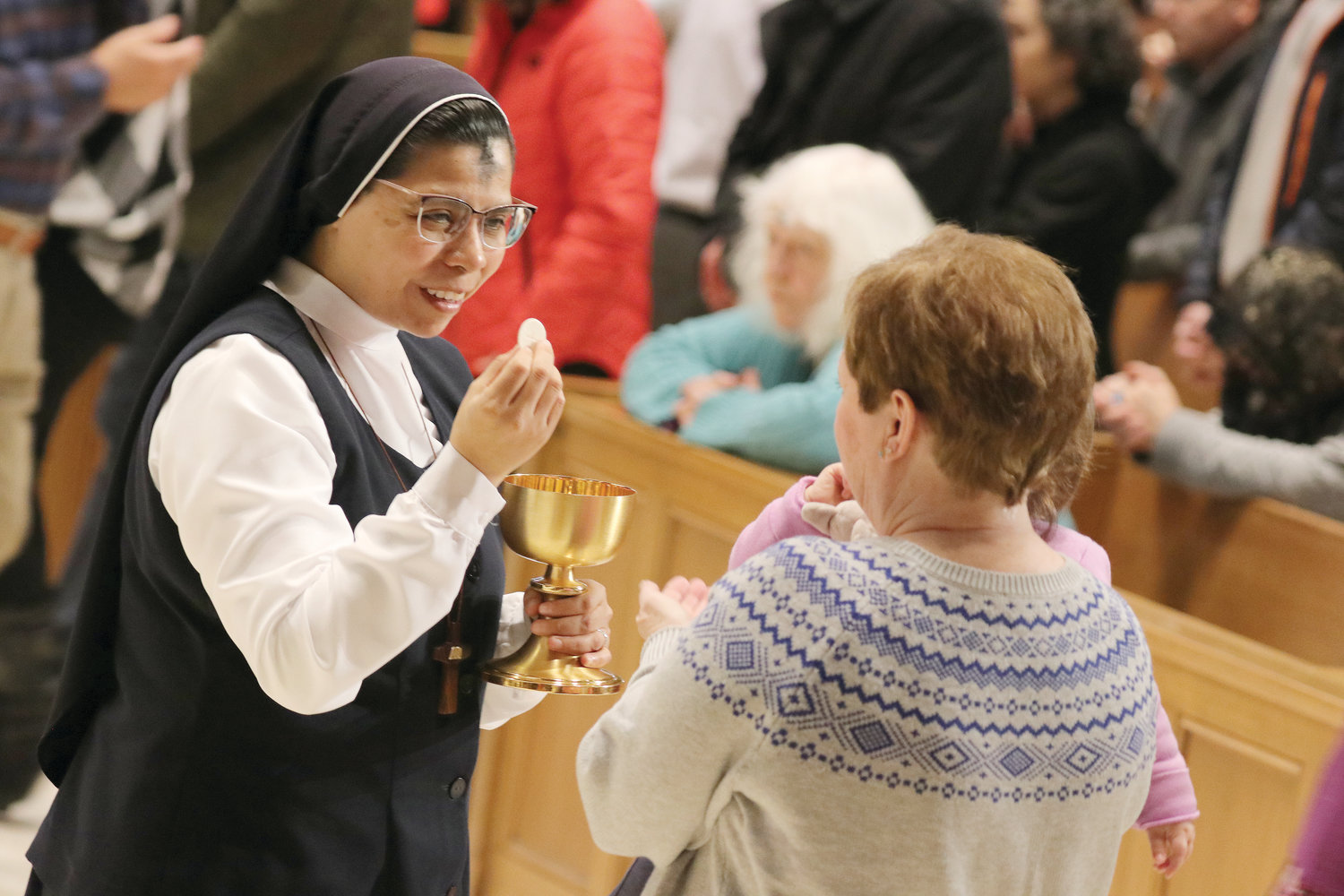 Sister Elizabeth Castro, H.M.S.P., director of the Office for Religious, offers Holy Communion. 